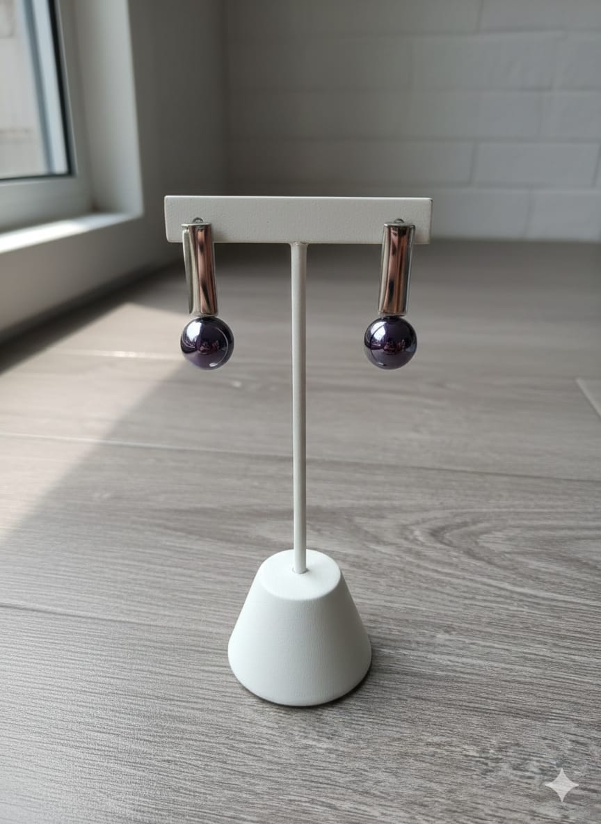 Pair of earrings on a white stand against a neutral background