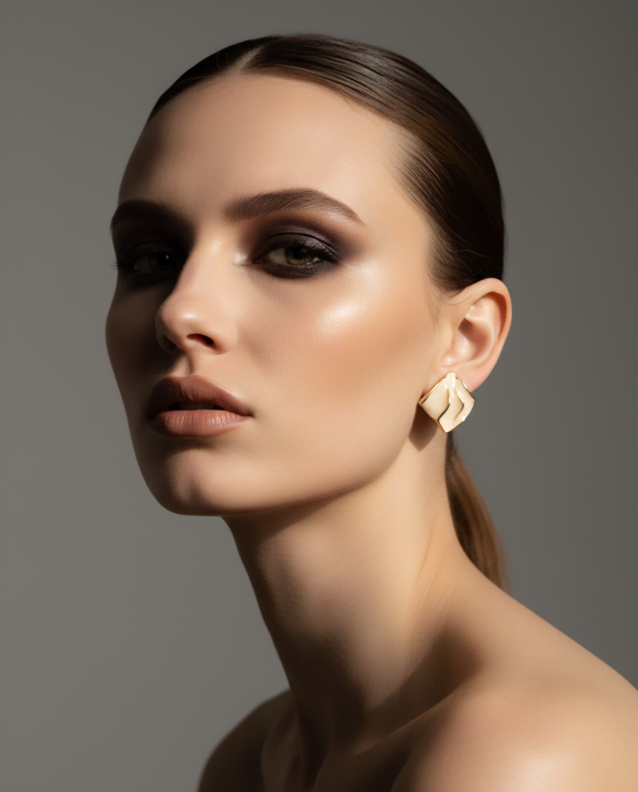 Woman wearing elegant earrings against a neutral background